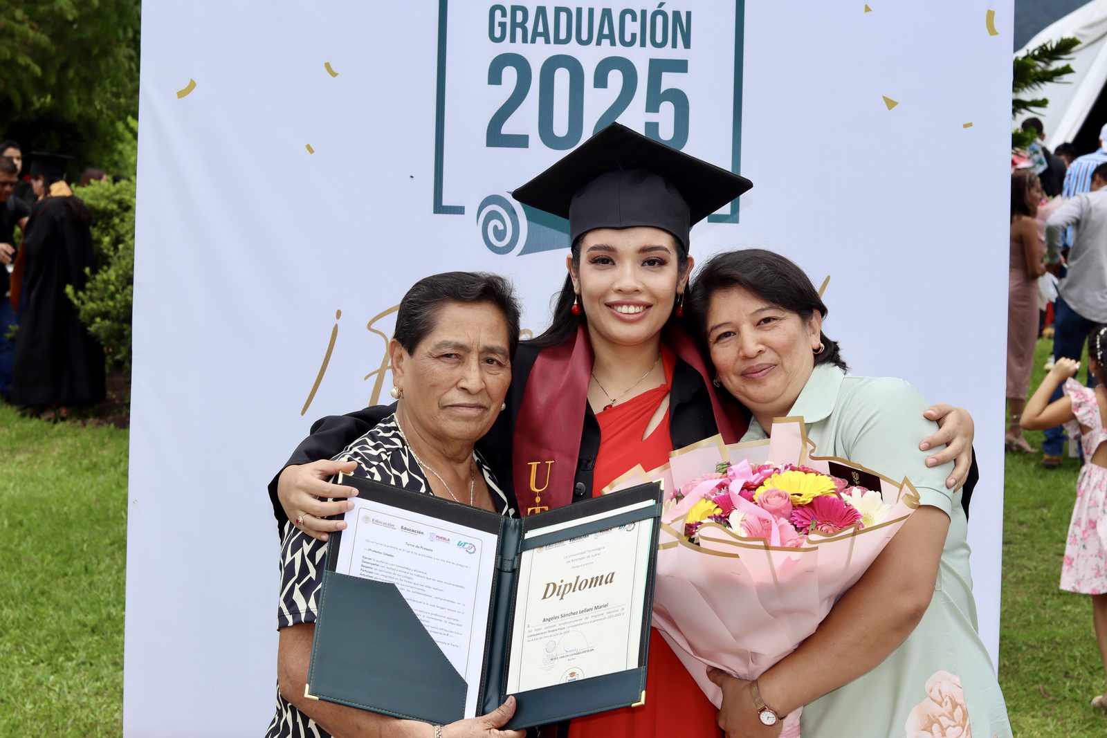Graduada con su familia al recibir el diploma