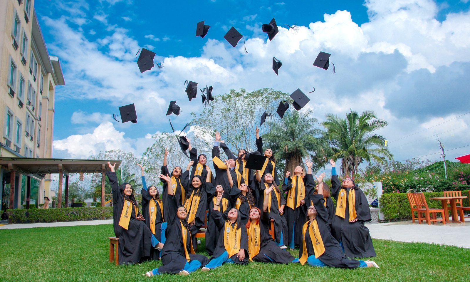 Fotopanorámica de generación lanzando birretes al aire